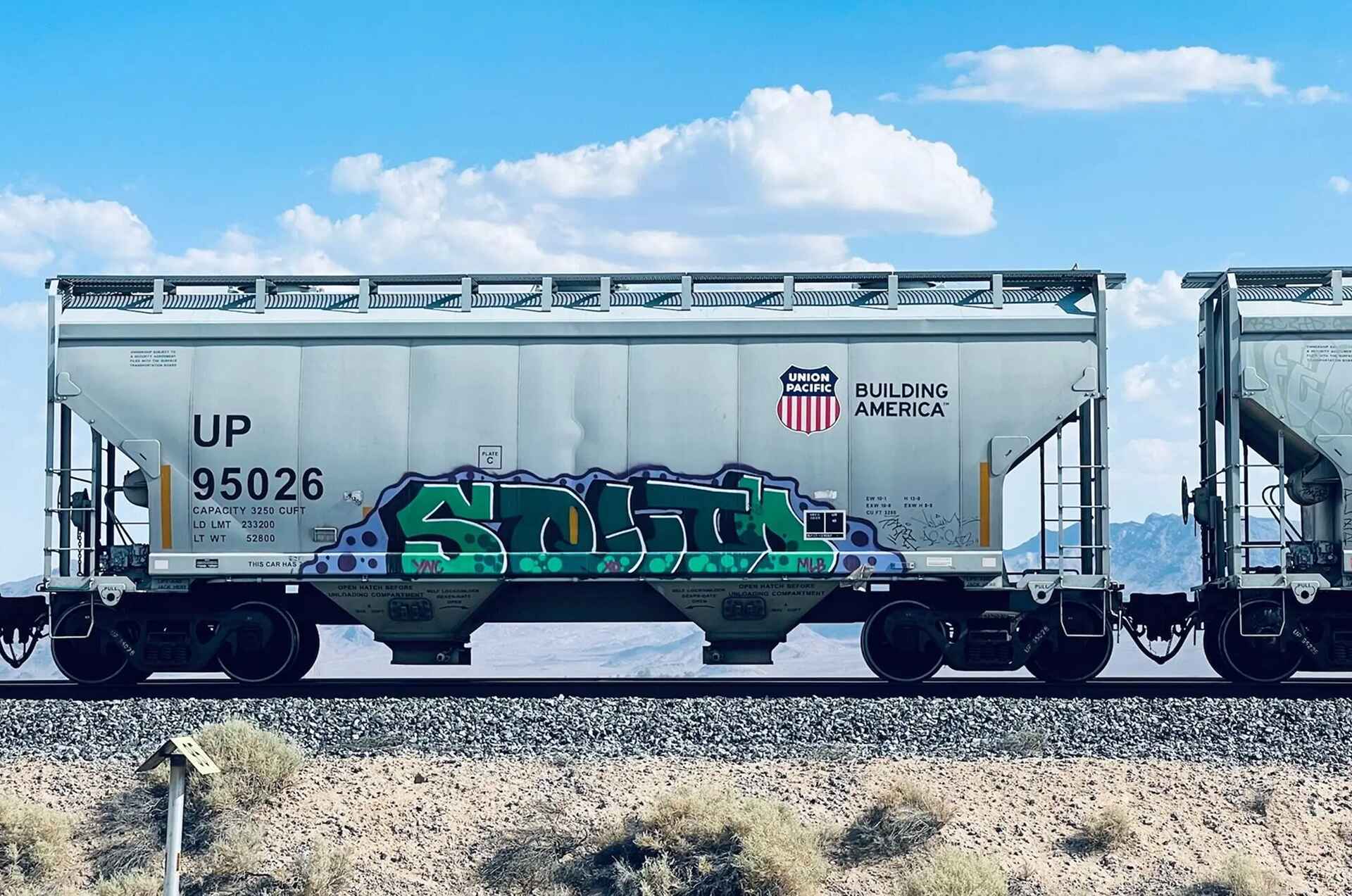 rail car hauling freight traveling along a desert railroad